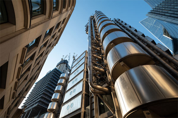 Looking up at modern skyscrapers and office buildings against a clear blue sky
