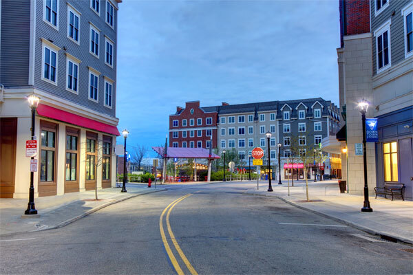 Commercial properties and storefronts along a downtown street at dusk